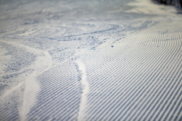 Snow grooming for groomed ski trails. Corduroy snow pattern close up. Fresh ski slope trail surface...