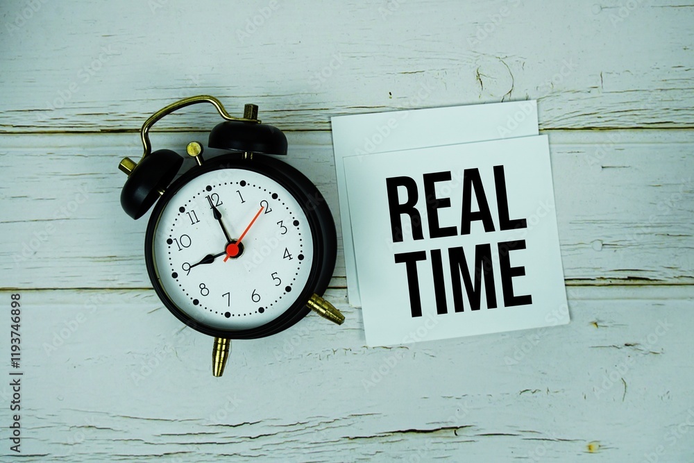 Poster real time text message on sticky note with alarm clock on wooden background