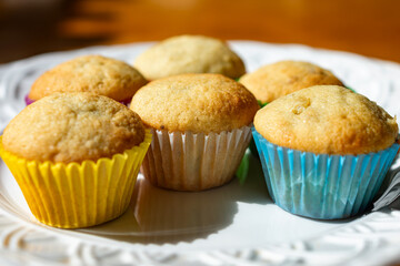 Mini banana muffins sit on a white plate.