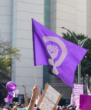 Bandera purpura con pu&ntilde;o en alto feminista, en marcha del d&iacute;a internacional de la mujer en M&eacute;xico