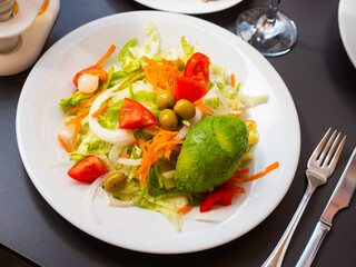 Appetizing salad of fresh vegetables served with avocado on platter
