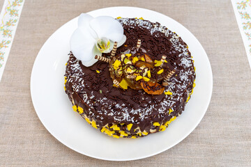 Delicious chocolate cake decorated with flowers and fruit at a party