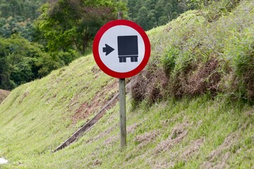 Placa de sinalização de transito caminhão a direita com seta indicando e na cor vermelha.