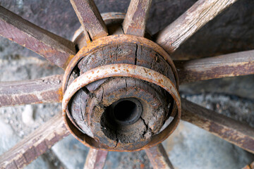 Old wooden wheel against the wall. Village life.