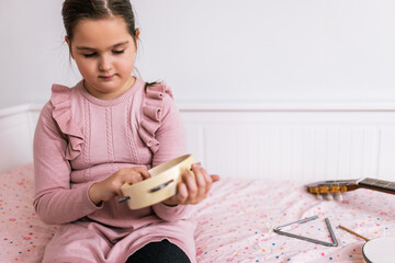 Little girl playing tambourine.