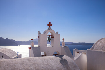 Oia, Santorini, Greece. White washed Greek buildings and Greek church bells overlooks the caldera