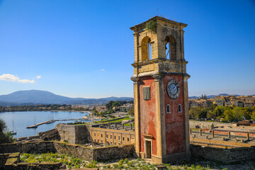 Corfu, Greece. Old clock terra cotta tower and view of Corfu, old town and the bay