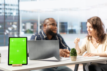 Property realtor showing blueprints to woman next to isolated mockup tablet, discussing leasing contract terms or rental agreement for high class office space. Business relocation plans.