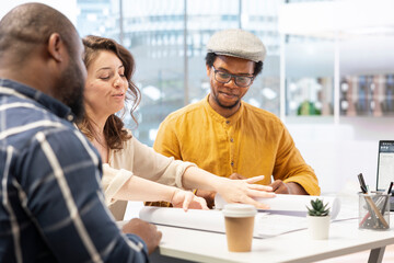 Real estate agent providing layout blueprints to clients in evaluating investment opportunity for leasing a new office space. Business team negotiating with realtor, contract agreement.