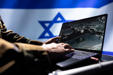Israel IDF military personnel working on laptop, analyzing aerial reconnaissance data to come up with warfare winning tactics. Close up shot of notebook used to control drones attacking strategic