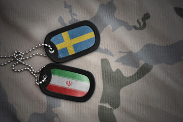vintage army blank, dog tag with flag of sweden and iran on the khaki texture background. military...