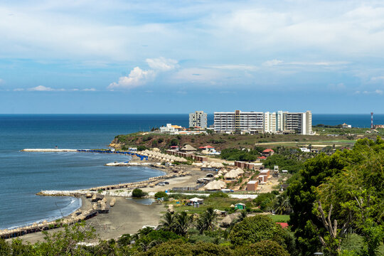 An aerial view of Salgar, Colombia, showcasing its beautiful coastline lined with rustic beach huts and modern residential developments
