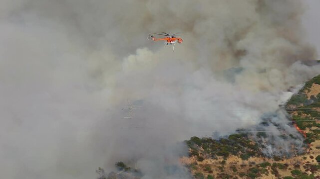 Firefighters are using helicopters to combat wildfires in Los Angeles, Malibu, and Pacific Palisades. The fires threaten the community, prompting urgent emergency response efforts