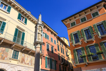 Obraz premium Verona, Italy. Colorful painted buildings in old town with shutters and a statue of a saint
