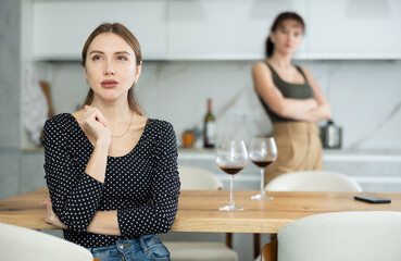 Two women have unpleasant conversation in dining room. Friends quarrel, sort things out, and accuse each other