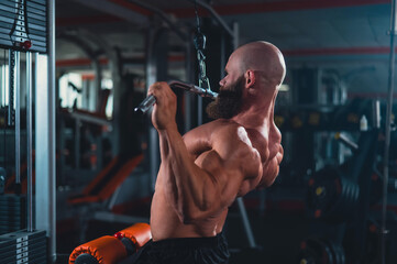 Caucasian man doing lat pull-downs on a machine. 