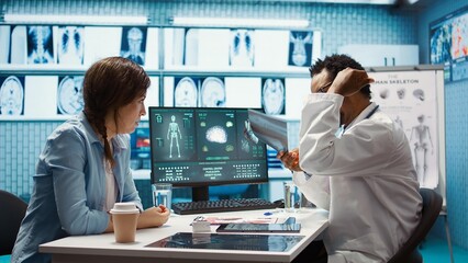 African american physician presenting the x ray diagnostics results to a patient, examining the...