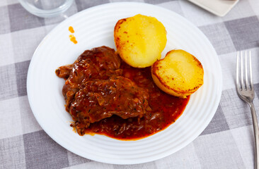 Tasty portion of roasted pork with potatoes served beautifully on plate