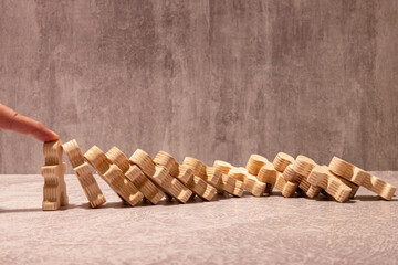 Close up of businessgirl hand Stopping Falling wooden Dominoes effect from