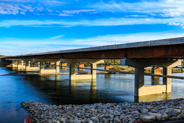 Obraz premium A bridge spans a river with a blue sky in the background