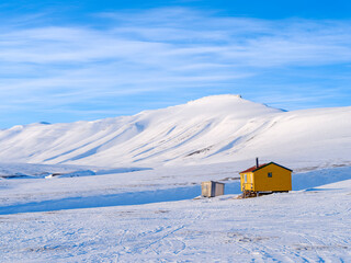 Fototapeta premium Huts called Semmelbu. Valley Semmeldalen during winter, Van Mijenfjorden National Park, on the island of Spitsbergen in the Svalbard Archipelago. Arctic, Norway.