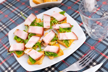 Toast with bacon and arugula served for breakfast on platter