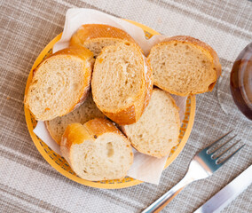 Bread sliced and served on table with olives and serving pieces
