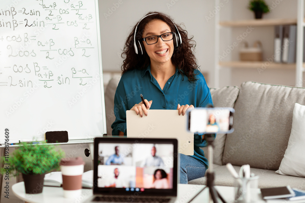 Poster studying online. smiling lady teacher in eyeglasses and headphones giving lesson on web, using smart