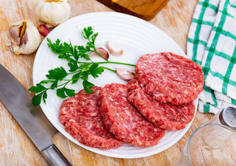 Cooking ingredients, raw burger cutlets on wooden board