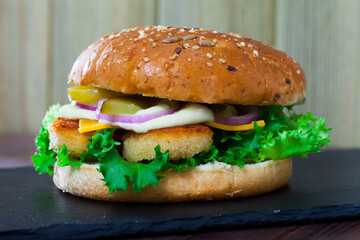 Delicious homemade cheeseburger with chicken nuggets, cheese and vegetables