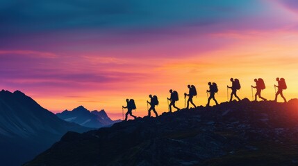 Fototapeta premium Adventurers Hiking Silhouetted Against a Colorful Sunset Sky