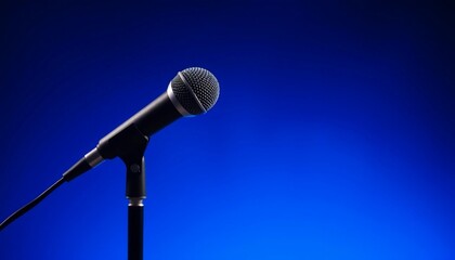 Obraz premium Professional Microphone on Stand Against Vibrant Blue Background Ideal for Audio Music and Podcast