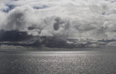 Dramatic seascape with dark storm clouds in the sky over the ocean water