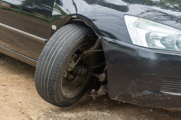 Damage to front wheels and suspension. Car with broken wheel standing in parking lot, bent axle.