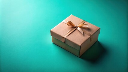 Obraz premium A simple brown gift box tied with a golden ribbon sits on a teal background