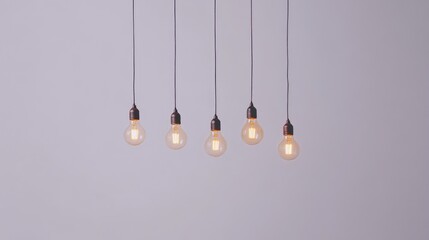 A row of hanging light bulbs symbolizing creativity and innovation in business, set against a minimalist white background.