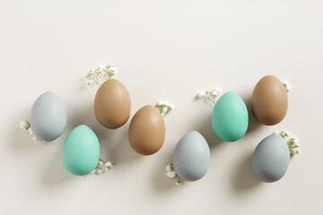 Easter Aesthetic with Matte Eggs and Delicate Florals, painted chicken egg decorated white flowers, top view on beige background, spring holiday concept. Minimal style pattern in pastel tones