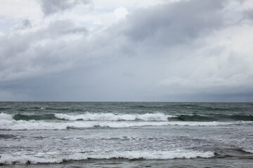 A tropical storm accompanied by rain came from the Indian Ocean accompanied by gloomy dark cloudy skies, turbulent sea waves around the coast.