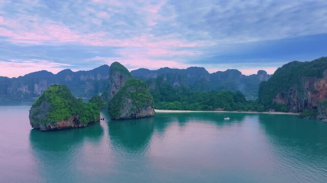 Explore Krabi, Thailands enchanting landscapes with aerial views of tranquil waters, islands, and a traditional longtail boat at sunset for an unforgettable experience