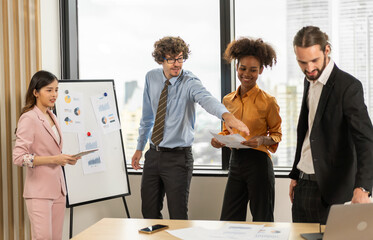 Diverse team brainstorming business meeting, professional presentation with data charts, team collaboration for project planning, modern corporate office teamwork, group discussing business strategies