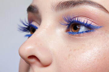 Human female face with blue eyes eyelashes makeup.
