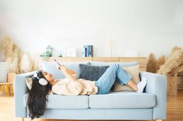 High angle view of happy cheerful positive young Asian woman on the phone at home, female smiling...
