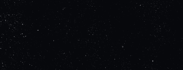 A black background with a speckled texture, resembling a starry night. The background is dark and black, creating a cosmic feel. Speckled wall texture background. Black background vector.