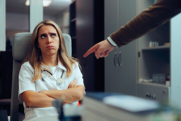Man Pointing to a Doctor Accusing of Malpractice. Patient suing a general practitioner accusing of...