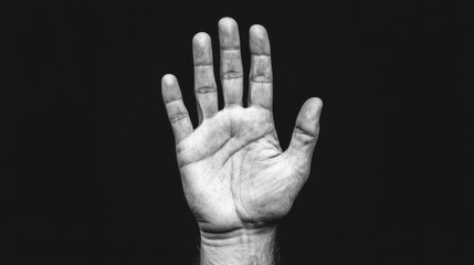 Close-up monochrome image of a man's hand, palm facing forward, against a black background.