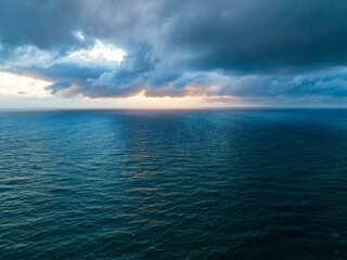 Dramatic ocean sunrise, stormy clouds. Vastness of the sea. Mercer Bay Loop, Piha, Auckland, New Zealand