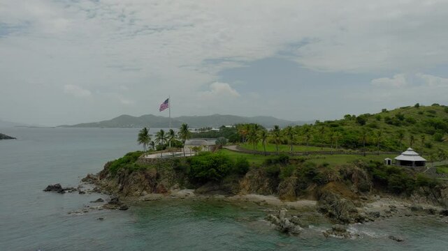 Aerial: Drone Panning Flag Of United States Waving On Epstein Island, Drone Flying Over Wavy Sea - VI, 
Little Saint James, United States of America