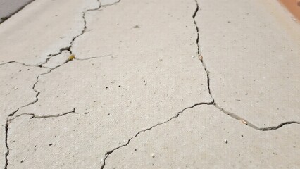 Fototapeta premium Outdoor cement sidewalk showing cracks, chips, and wear due to long-term exposure and foot traffic.