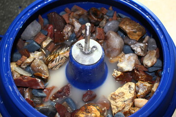 Vibratory tumbling bowl filled with stones for processing