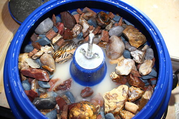 Vibratory tumbling bowl filled with stones for processing